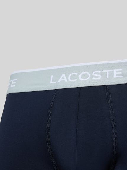 Produktfoto, dunkelblaue Trunk aus Baumwoll-Mix im 3er-Pack von Lacoste, elastischer Bund mit weißem Lacoste-Schriftzug, glatte Oberfläche. Herren Pant & Trunk von Lacoste