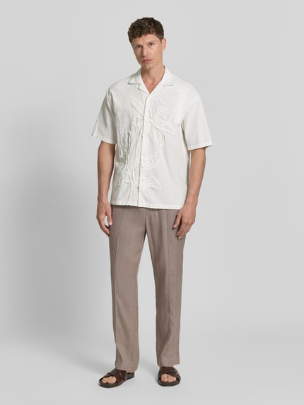 Männermodel trägt Straight Fit Schmale Hose aus Leinen-Lyocell-Mix Modell 'CINO' von HUGO in Beige, unifarben, Ganzkörperansicht von vorne.