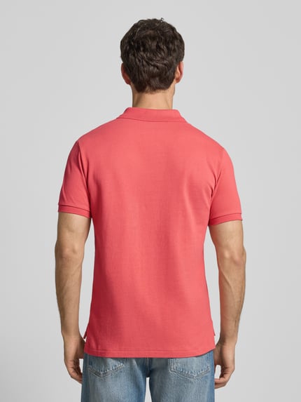 Męski model nosi Koszulkę polo z wyhaftowanym logo Polo Ralph Lauren z bawełny, krój regular fit, kołnierzyk polo, prążkowane zakończenia rękawów, długość tyłu 68 cm w rozmiarze M, widok całej sylwetki od tyłu.