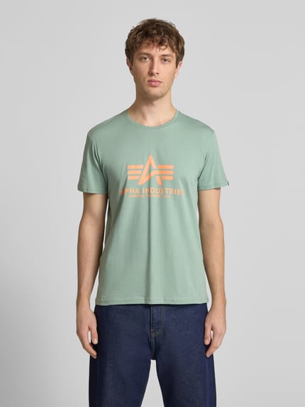 Männermodel trägt T-Shirt mit Label-Detail Modell 'BASIC' von Alpha Industries in Mint, Reine Baumwolle, Gerader-Schnitt, Rundausschnitt, Ganzkörperansicht von vorne.