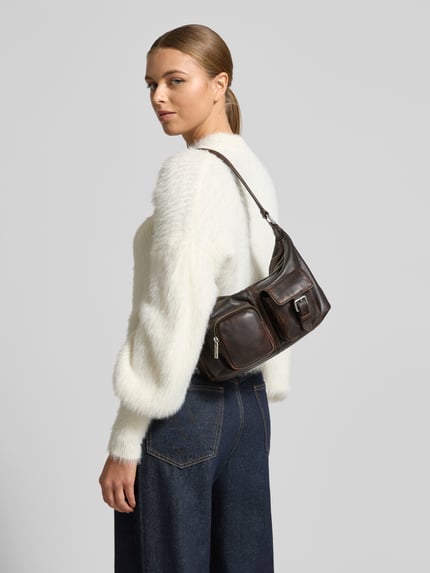 Frauenmodel trägt Shoulder Bag mit Reißverschluss Modell 'Andrea' von LIEBESKIND BERLIN in Dunkelbraun, mehrere Fächer, Ganzkörperansicht Rückansicht.