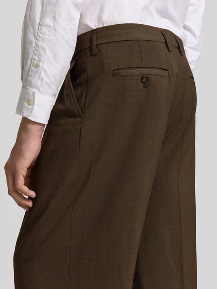 Männermodel trägt Relaxed Fit Stoffhose aus Baumwoll-Mix von Juvia in Braun mit Eingriffs- und Gesäßtaschen, Nahaufnahme Rückansicht. Herren Stoffhose, Kellerfalten, Knopf- und Reißverschluss, Innenbeinlänge 81 cm, Bundweite 44 cm.