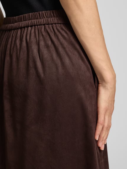 Frauenmodel trägt Midirock in Leder-Optik mit elastischem Bund von Smith and Soul, dunkelbraun, A-Linie, Material-Mix, Nahaufnahme Hüfte.