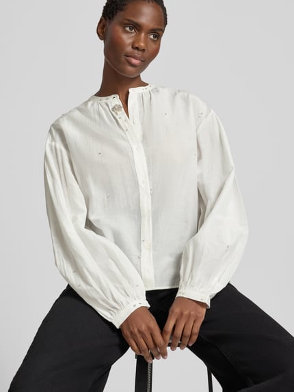 Männermodel trägt Regular Fit Bluse mit Ziersteinbesatz von Luisa Cerano, okrągły dekolt, listwa guzikowa, długość tyłu 66 cm, długość rękawów 56 cm, bluzka z długim rękawem, kolor biały, gładka tekstura, Ganzkörperansicht von vorne.