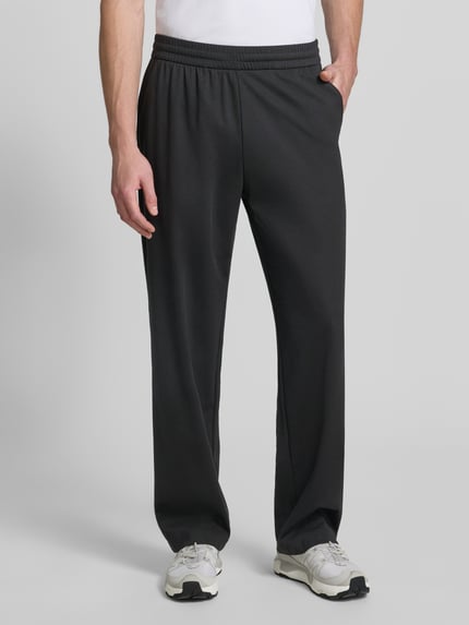 Männermodel trägt schwarze Sweatpants mit elastischem Bund von Emporio Armani, Lyocell-Mix mit Viskose-Anteil, Relaxed-Fit, Eingrifftaschen, Herren, Ganzkörperansicht von vorne.