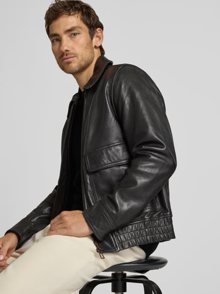 Männermodel trägt Lederjacke aus Schafsleder mit Pattentaschen von Paul Smith, Bomber Fit, Kentkragen, Nahaufnahme Oberkörper.