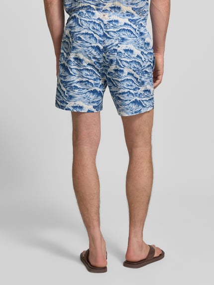 Mannelijk model draagt Straight Fit Badehose mit elastischem Bund van Gant, blauwe en witte all-over print, elastische taille, straight fit, tunnelkoord, product uit context, volledige lichaamsweergave achterkant.