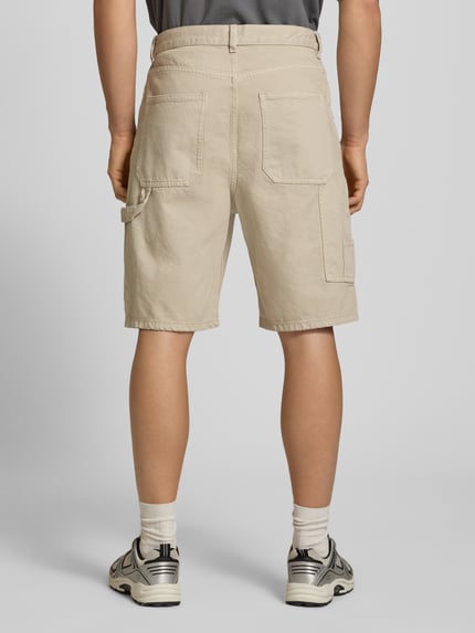 Männermodel trägt Bermudas mit seitlichen Eingrifftaschen von REVIEW aus reiner Baumwolle in Straight Fit, Ganzkörperansicht Rückansicht.