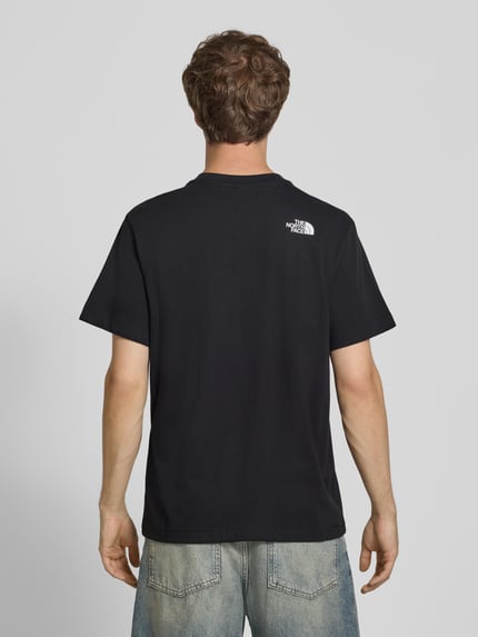 Mannenmodel draagt t-shirt met motiefprint Model 'DONKEY TAXI' van The North Face in zwart, puur katoen, regular fit, ruglengte maat M 70 cm, logoprint, geheelbeeld achterkant