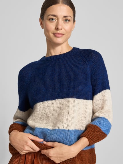 Frauenmodel trägt Relaxed Fit Pullover mit Woll-Anteil in Strick-Optik von MORE, blau, creme, hellblau, braun, Nahaufnahme Oberkörper. Material-Mix, Rundhalsausschnitt, 3/4-Arm, Rückenlänge 55 cm, Ärmellänge 44 cm.