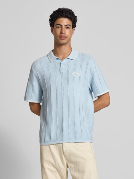 Męski model nosi Regular Fit Poloshirt in Strick-Optik model 'Menton' od Jack & Jones, bawełna, krój regular fit, jasnoniebieska, z krótkim rękawem, imitacja dzianiny, długość tyłu w rozmiarze M: 70 cm, koszulka polo; całkowity widok z przodu.