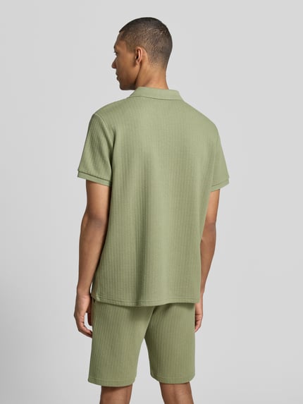 Männermodel trägt Regular Fit Strick-Poloshirt mit V-Ausschnitt von MCNEAL aus Baumwoll-Mix mit Stretch-Anteil, Rückenlänge 70 cm, Ganzkörperansicht Rückansicht.