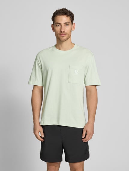 Mężczyznamodel nosi Regular Fit T-Shirt aus reiner Baumwolle Modell 'DARRO' od HUGO, kolor jednolity, krój regular fit, biały nadruk z logo, okrągły dekolt, krótki rękaw, gładka bawełniana dzianina jersey, widok całej sylwetki z przodu.