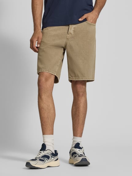 Männermodel trägt Regular Fit Jeansshorts aus reiner Baumwolle Modell 'EDGE' von Only & Sons in Beige mit 5-Pocket-Design, Ganzkörperansicht von vorne.