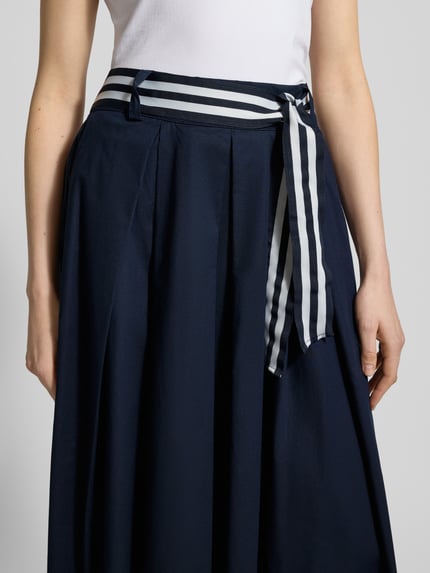 Vrouwenmodel draagt Midirok met elastische band en strikceintuur van More & More, mix van katoen en elastaan, A-lijn, detailopname taille