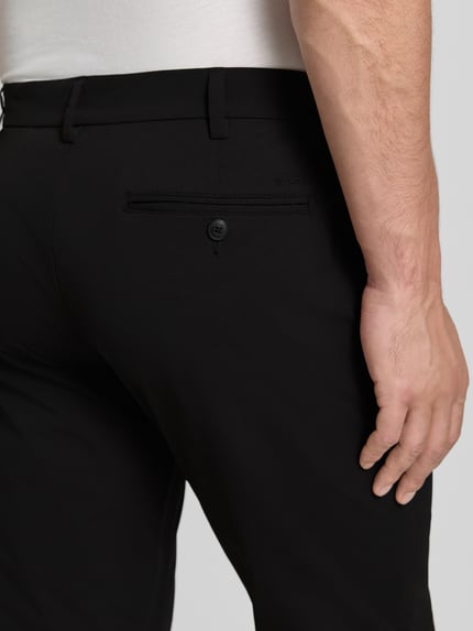 Männermodel trägt Slim Fit Hose mit Gesäßtaschen von MCNEAL in Schwarz, Knopf-Reißverschluss, Eingrifftaschen, Detailaufnahme Rückansicht.