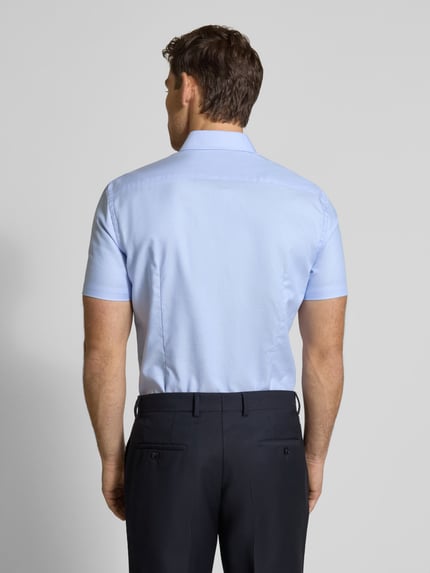 Męski model nosi Slim Fit Business-Hemd aus Baumwolle mit Kentkragen od Jake*s, jasnoniebieski, gładka bawełna, krój slim fit, krótki rękaw, guzikowa listwa, długość pleców w rozmiarze 39/40: 78 cm, szerokość ramion w rozmiarze 39/40: 47 cm, długość rękawa w rozmiarze 39/40: 24 cm, widok całej sylwetki od tyłu.