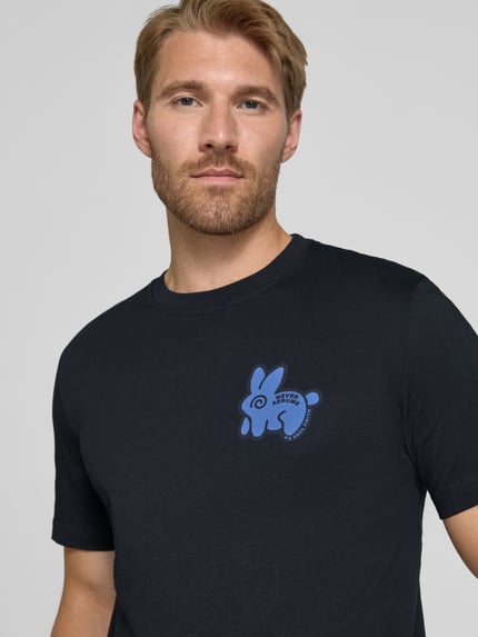Männermodel trägt Regular Fit T-Shirt aus reiner Baumwolle von Paul Smith, dunkles Blau, Rundhalsausschnitt, Statement-Print, Nahaufnahme Oberkörper.
