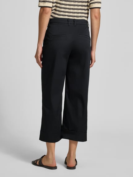 Vrouwenmodel draagt Wide Leg Culotte aus Baumwoll-Mix van s.Oliver RED LABEL in effen zwart met vouwplooien, 7/8-lengte, high waist, achteraanzicht volledige lichaamsopname.