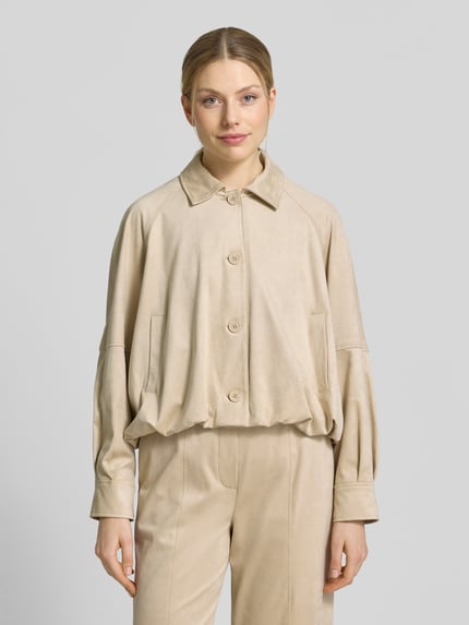 Vrouwenmodel draagt Jacke mit Knopfleiste und Eingrifftaschen Modell 'Nayomi' van Someday in beige, materiaalmix met stretch, relaxed fit, platte kraag, knoopsluiting, steekzakken, ruglengte maat 36: 52 cm, schouderbreedte 42 cm, borstwijdte 66 cm, mouwlengte 60 cm, gehele lichaamsaanzicht van voren.