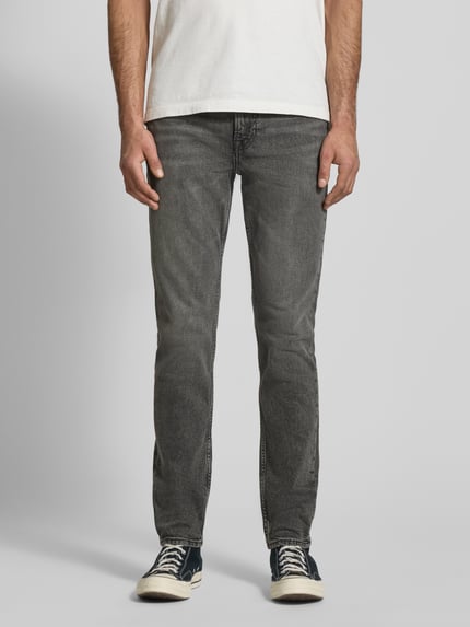 Męski model nosi Slim Fit Jeans mit Label-Patch Modell 'HEARST' von Calvin Klein Jeans, szary denim, bawełna z domieszką, krój slim fit, pięć kieszeni, efekt used-look, szerokość w rozmiarze 31/32: 40 cm, długość nogawki wewnętrznej: 80 cm, widok całej sylwetki z przodu.
