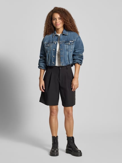 Frauenmodel trägt Cropped Jeansjacke mit Knopfleiste von Calvin Klein Jeans aus reiner Baumwolle im lockeren Schnitt, Ganzkörperansicht von vorne.