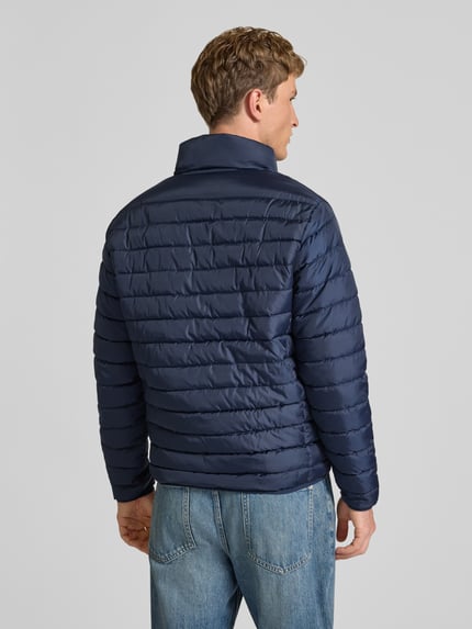 Männermodel trägt dunkelblaue Jacke mit Label-Patch Modell 'ELVIS' von JACK & JONES, gesteppte Struktur, Rückenansicht, Ganzkörperansicht Rückansicht.