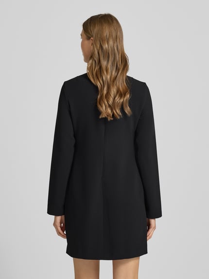 Frauenmodel trägt Minikleid mit Stehkragen von Calvin Klein Womenswear, Schwarz, Elastischer-Material-Mix, taillierte Passform, Rückenreißverschluss, Rückenlänge 85 cm, Brustweite 39 cm, Ärmellänge 60 cm, Ganzkörperansicht Rückansicht.