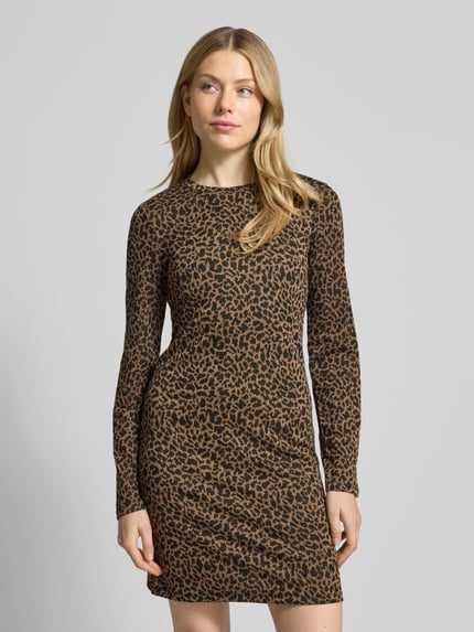 Vrouwenmodel draagt Regular Fit Freizeitkleid mit Animal Print van Vero Moda met allover animal print, mini lengte, lang mouw; vooraanzicht van het hele lichaam.