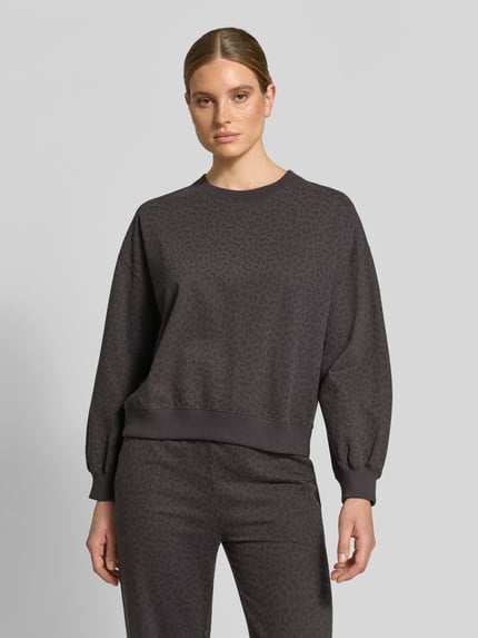 Vrouwenmodel draagt Oversized Sweatshirt aus Baumwoll-Mix van Juvia in donkergrijs met luipaardpatroon, ronde hals, verlaagde schouders, elastische boorden, ruglengte maat S: 55 cm, frontale opname van het hele lichaam.
