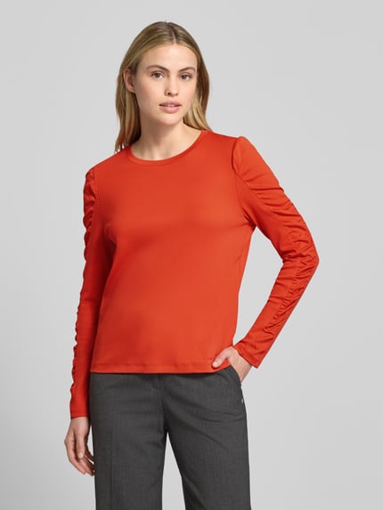 Kobiece modelka nosi Longsleeve mit Puffärmeln und Rundhalsausschnitt od Marc Cain w kolorze czerwonym, regular fit, bawełna z elastanem, widok z przodu, ujęcie do pasa.