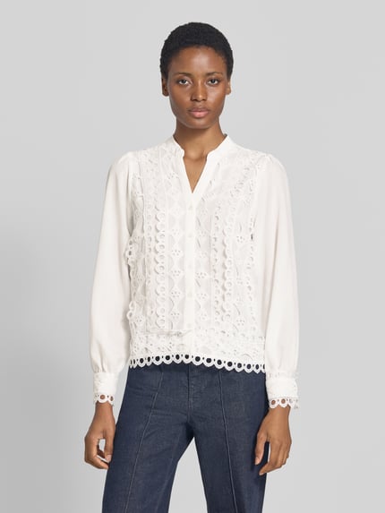 Frauenmodel trägt Bluse mit Viskose-Anteil von MORE & MORE in Weiß mit Spitzenbesatz und taillierter Passform, Ganzkörperansicht von vorne.