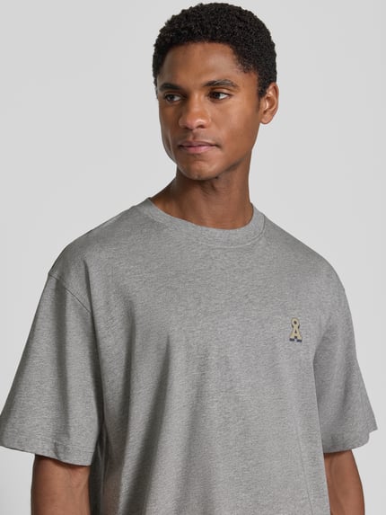Männermodel trägt grijs Heren oversized shirt van katoen, Relaxe Fit Oversized Shirt aus reiner Baumwolle Modell 'ICONIC Å MAARKOS' van ARMEDANGELS, Nahaufnahme bovenlichaam