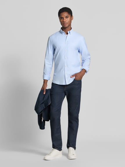 Männermodel trägt Regular Fit Freizeithemd aus Baumwoll-Mix Modell 'Oxford' von Lindbergh in Hellblau, glatte Struktur, Ganzkörperansicht von vorne. Kontext: Baumwoll-Elasthan-Mix, Button-Down-Kragen, 1-Knopf-Manschetten, abgerundeter Saum, Rückenlänge 77 cm, Schulterbreite 44 cm, Ärmellänge 66 cm.