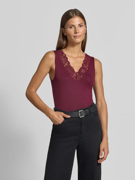 Vrouwenmodel draagt Regular Fit top uit viscosemix model 'ROSA' van VERO MODA, donkerrood met kant, Dames top, bovenlichaam vooraanzicht.
