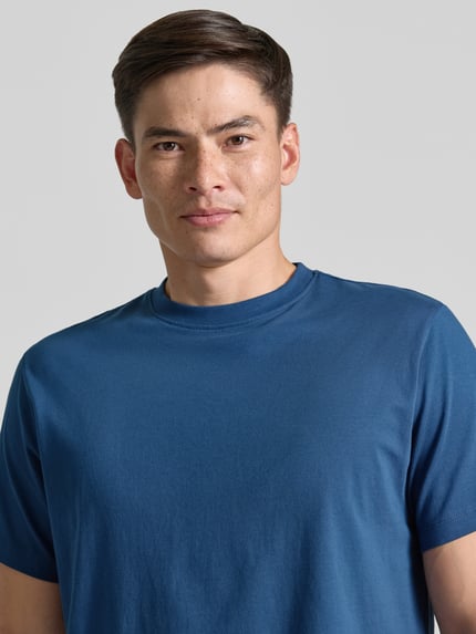 Männermodel trägt Regular Fit T-Shirt aus reiner Baumwolle Modell 'HASPEN' von SELECTED HOMME in Blau, Herren T-Shirt, Nahaufnahme Oberkörper.