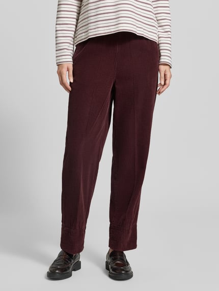 Frauenmodel trägt Straight Fit Hose aus reiner Viskose Modell 'Padow' von American Vintage in Dunkelrot mit Strukturmuster, elastischer Bund, Nahaufnahme Unterkörper, Damen Hose.