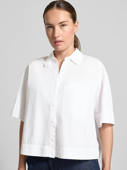 Vrouwenmodel draagt witte boxy fit blouse met korte mouwen van katoen model 'Filsona' van OPUS, Damesblouse, borstzak, Nahaufnahme Oberkörper.