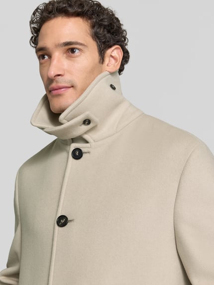 Männermodel trägt Regular Fit Mantel mit Eingrifftaschen von bugatti, Wollmix mit Kaschmir, cremefarben, Nahaufnahme Oberkörper.