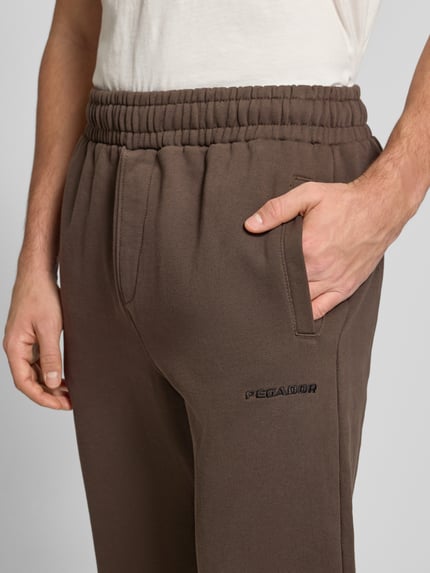 Männermodel trägt Sweathose mit elastischem Bund von Pegador, Baumwoll-Mix, Label-Stitching, französische Eingrifftaschen, Nahaufnahme Oberkörper.