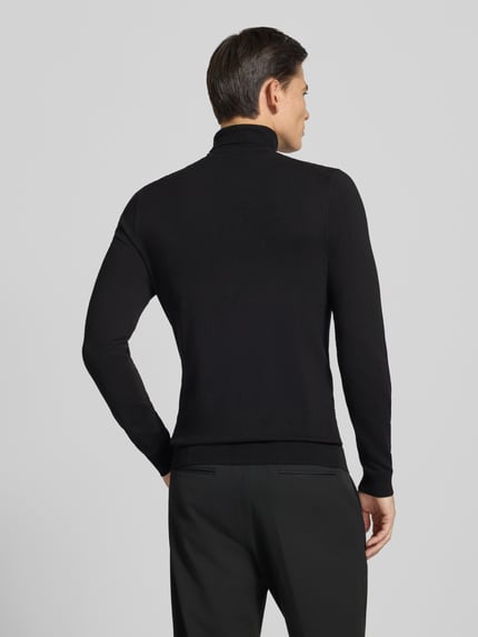 Männermodel trägt Slim Fit Rollkragenpullover aus Viskose-Mix mit Rippbündchen von MCNEAL, schwarze Farbe, Rückenansicht, Ganzkörperansicht Rückansicht.