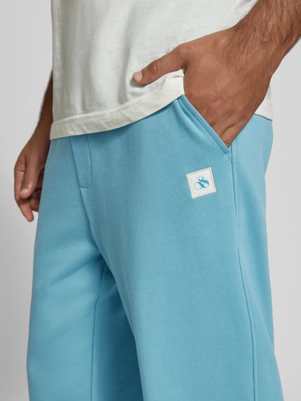 Männermodel trägt Sweatpants mit elastischem Bund und Tunnelzug von Scotch & Soda, reine Baumwolle, Regular Fit, Logo, Nahaufnahme Hüfte
