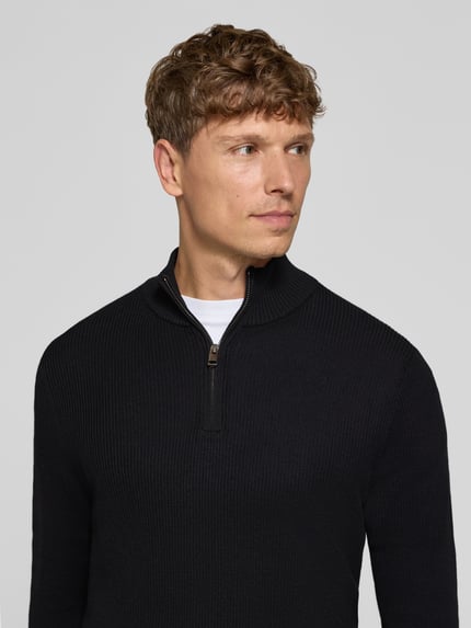 Männermodel trägt Regular Fit Troyer aus reiner Baumwolle von S.OLIVER CASUAL in unifarbener Strickoptik, Nahaufnahme Oberkörper.