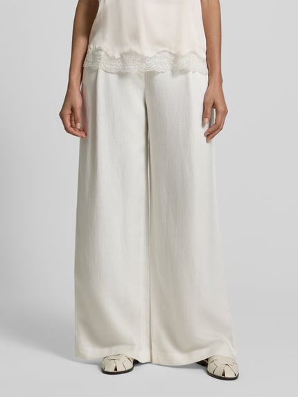 Frauenmodel trägt Stoffhose mit Gesäßtaschen von Jake*s Collection, Lockere Schnittform, Bundfalten, weiße Farbe, Nahaufnahme Oberkörper