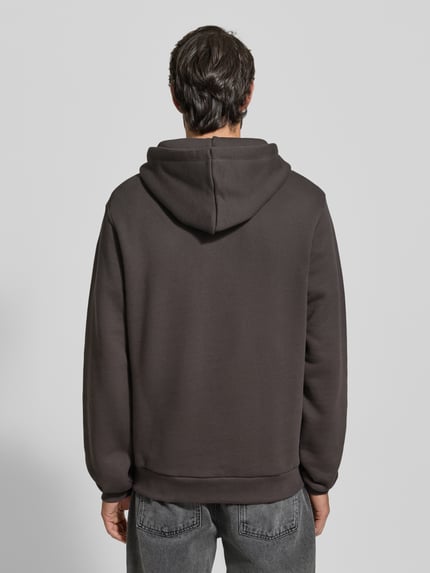 Männermodel trägt Hoodie mit Label-Print Modell 'Brady' von Les Deux in Dunkelgrau, Reine Baumwolle, Regular-Fit, Rückenansicht Ganzkörperansicht.