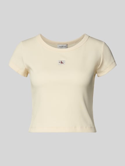 Produktfoto, Cropped T-Shirt in Ripp-Optik mit Label-Badge von Calvin Klein Jeans aus Baumwoll-Elasthan-Mix in zartem Creme, Rückenlänge 36 cm