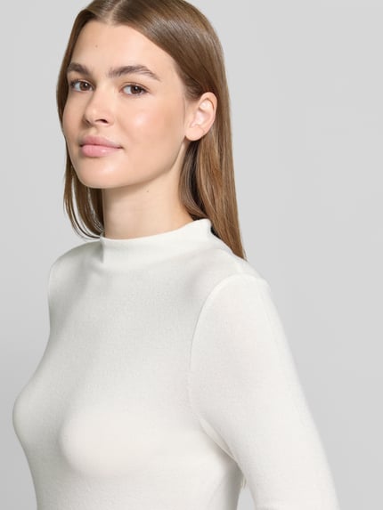 Frauenmodel trägt Langarmshirt Modell 'Sosemin' mit Rundhalsausschnitt von OPUS, unifarben, weiße Textur, Nahaufnahme Oberkörper.