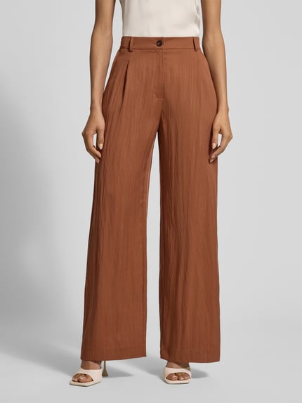 Frauenmodel trägt Stoffhose mit Eingrifftaschen und Gesäßleistentaschen von Jake*s Collection in Braun, Lyocell-Mix, Loose Fit, Ganzkörperansicht von vorne.