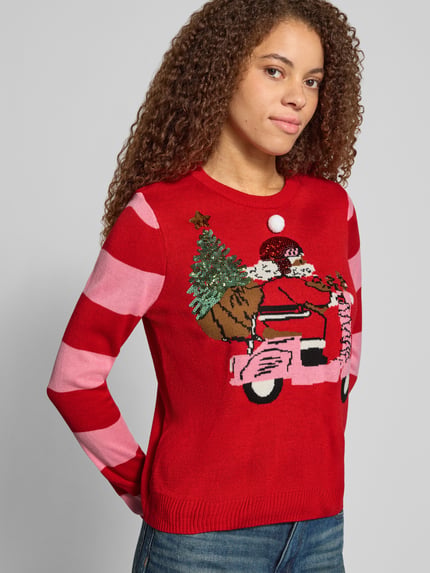 Frauenmodel trägt Rollkragenpullover mit weihnachtlichem Motiv-Print von ONLY in Rot mit rosa Streifen, Strickoptik, Nahaufnahme Oberkörper.