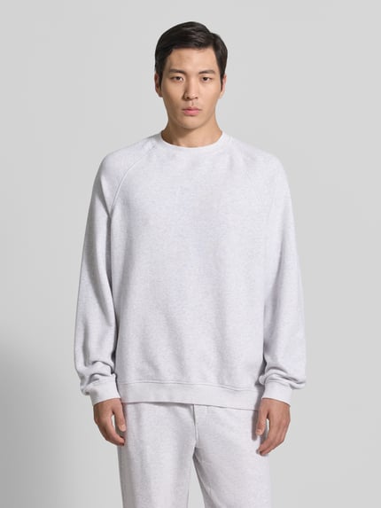 Männermodel trägt Sweatshirt mit Rundhalsausschnitt Modell 'ATUBAY' von American Vintage aus Baumwoll-Elasthan-Mix, hellgrau, Relaxed-Fit, Ganzkörperansicht von vorne. Rückenlänge 67 cm, Ärmellänge 77 cm bei Größe M/L.